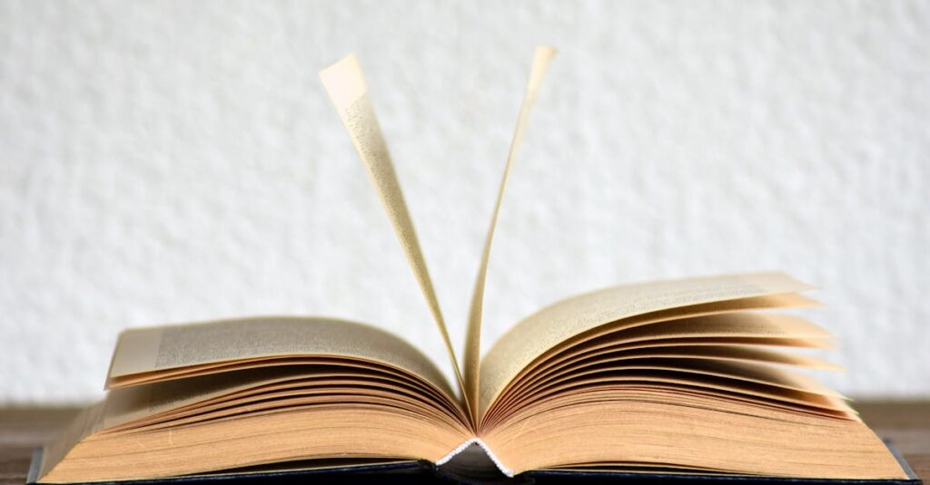 Close-up image of an open book with pages turning, creating a dynamic visual.