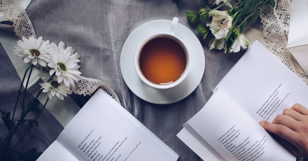 Inviting cozy reading setup with tea, poetry books, and fresh flowers on a table.